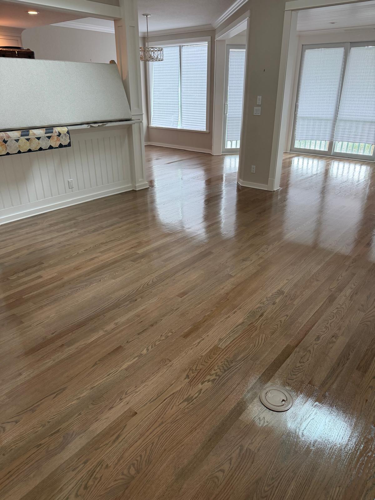 An open living and dining room with freshly finished natural oak hardwood flooring